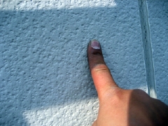 外壁を指で擦る